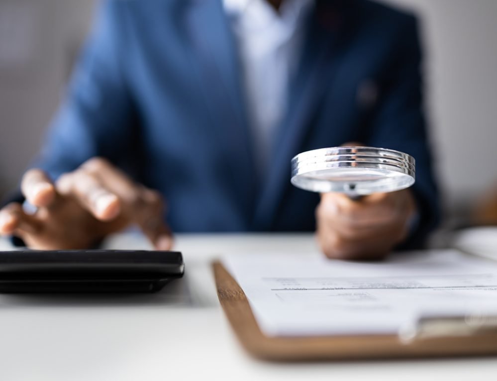 Business Fraud Investigation. Auditor Using Magnifying Glass To Investigate