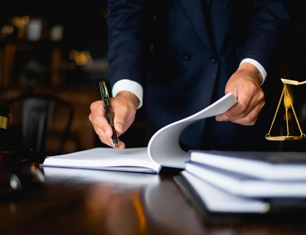 Close up lawyer businessman working or reading lawbook in office workplace for consultant lawyer concept.